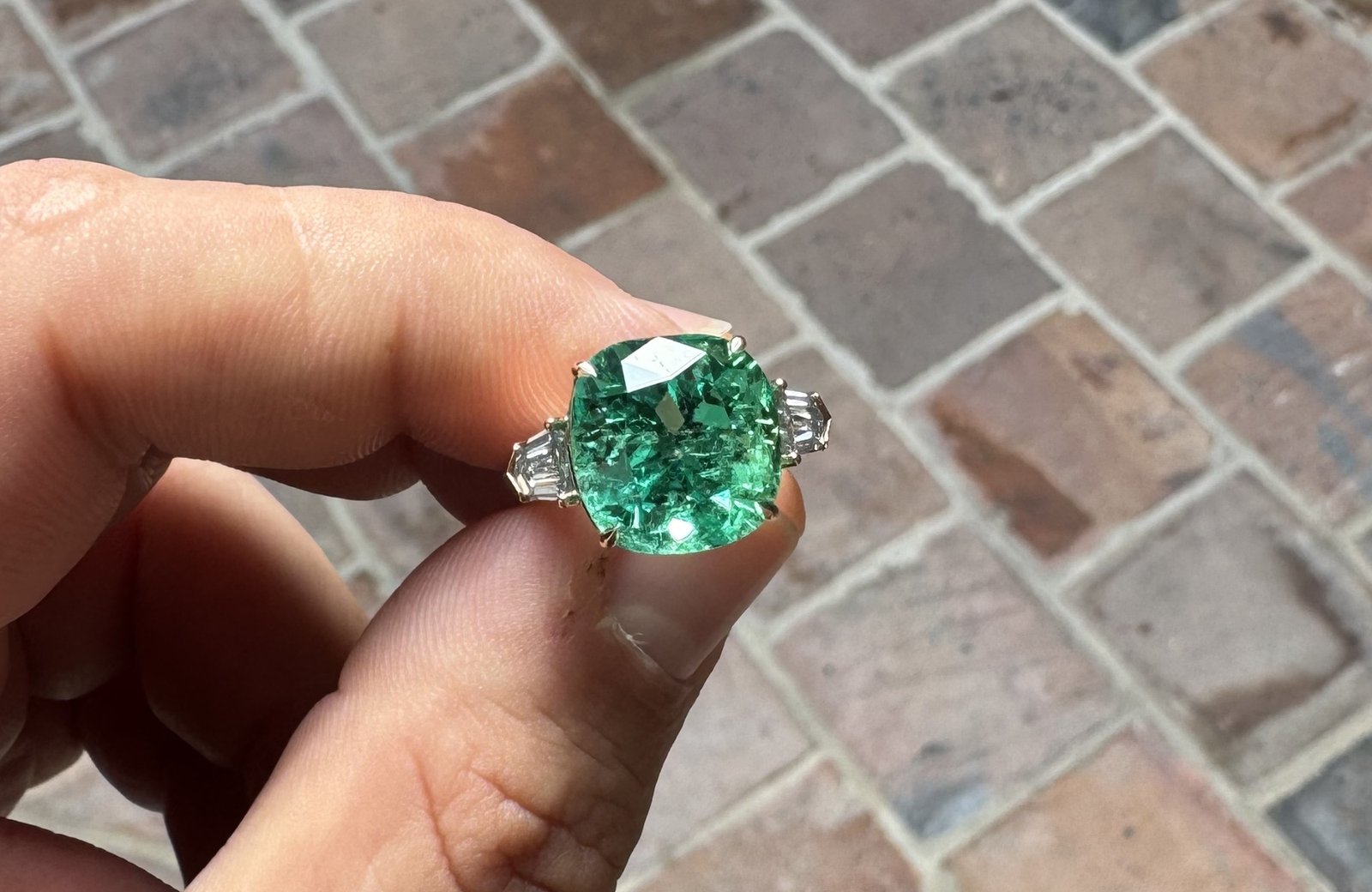 Guilhem Merolle tenant une bague sertie d'une émeraude colombienne